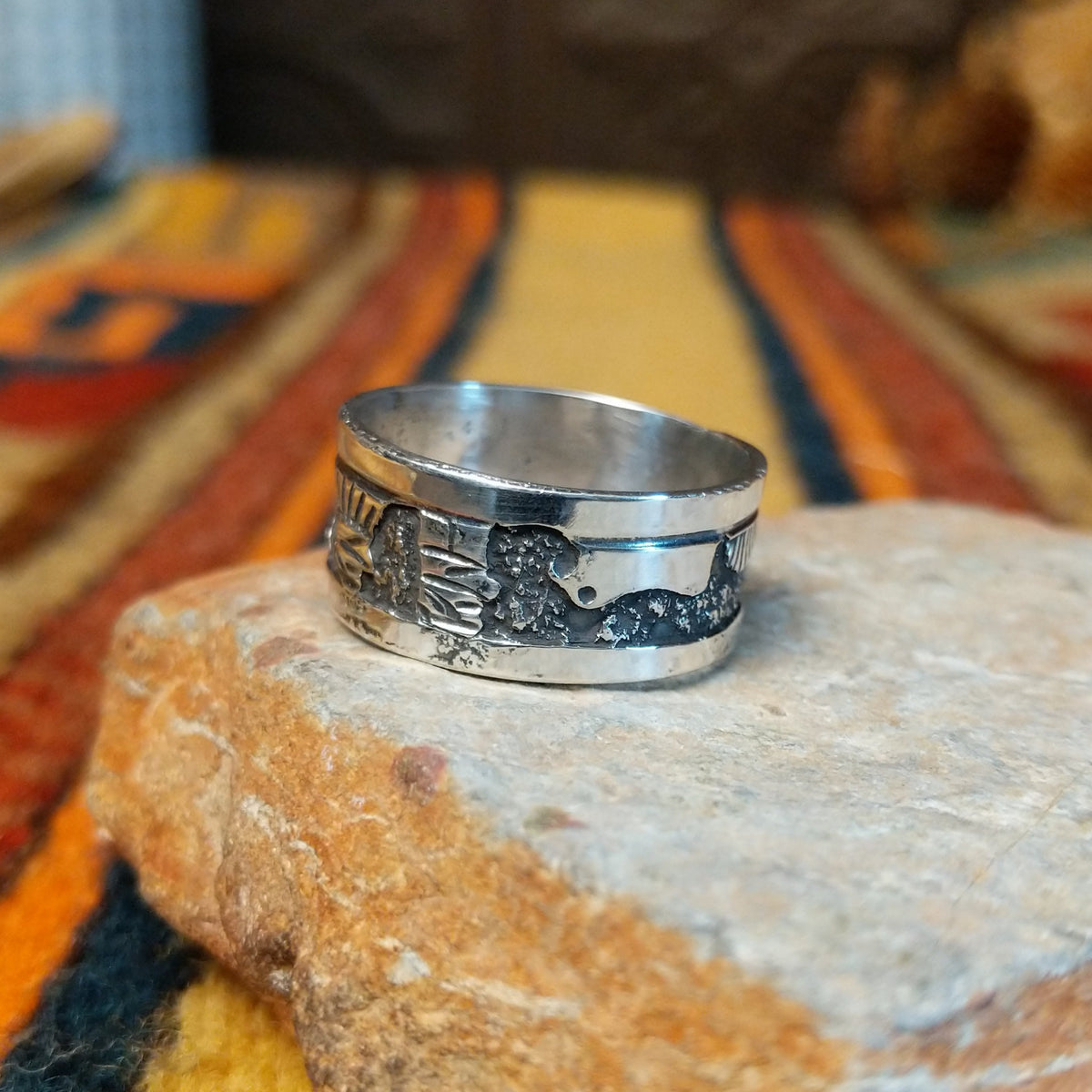 Silver Storyteller Ring by Elaine Becenti featuring a wide silver band with detailed landscape motifs, textured mountain designs, oxidized accents, and polished edges.