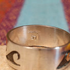 Silver Wave Ring by Lester Gene featuring a wide brushed silver band with a repeating oxidized wave pattern and polished lower border; artisan and Sterling Silver stamp.