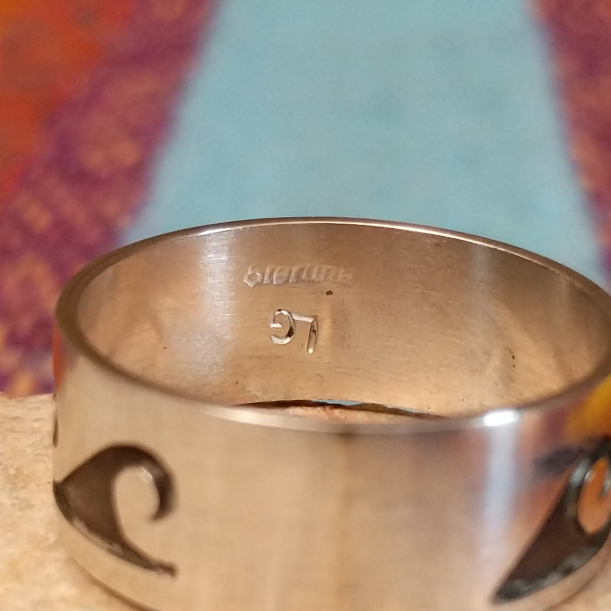 Silver Wave Ring by Lester Gene featuring a wide brushed silver band with a repeating oxidized wave pattern and polished lower border; artisan and Sterling Silver stamp.