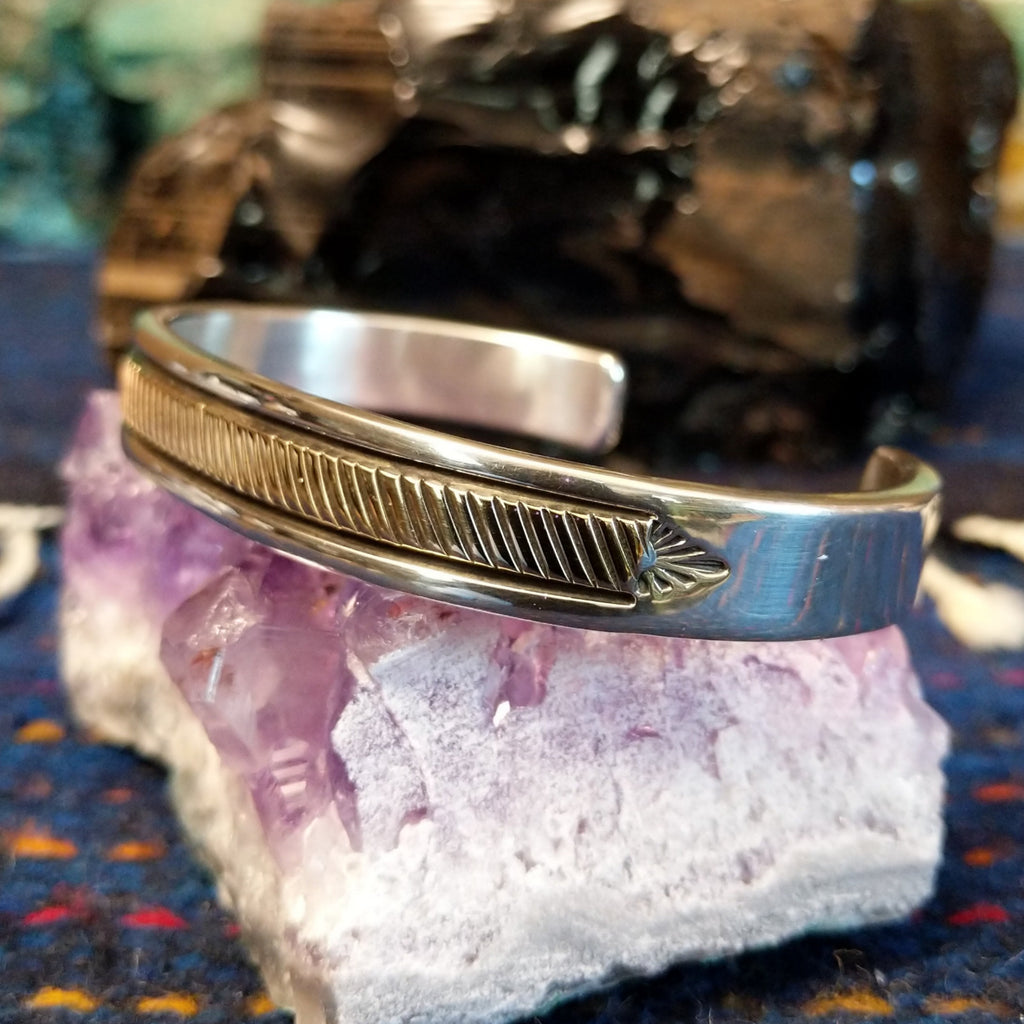 Slash-stamped sterling silver and polished gold cuff.