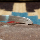 Slender silver feather cuff by Lena Platero, featuring a finely engraved sterling silver feather design in a handcrafted slim open cuff with polished finish.  Artisan and Sterling Silver stamp.