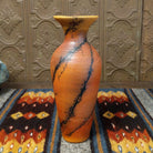 A terracotta vase with black horsehair rising along its narrow surface.