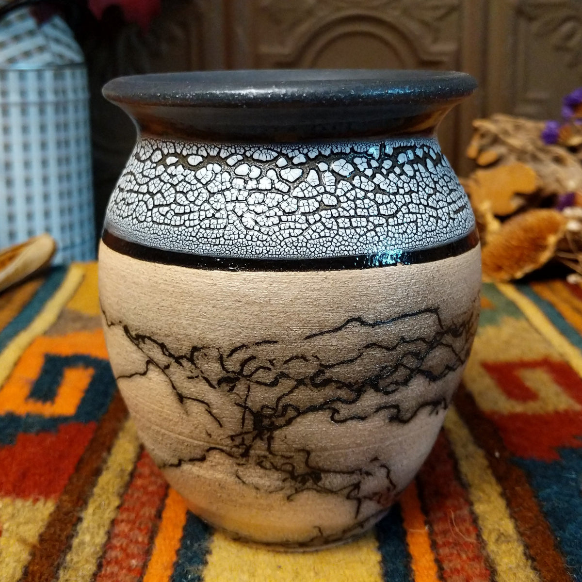 This distinctive Small Horsehair Pottery by Roger Calhoun features a tapered ceramic vessel with natural earth tones, black horsehair patterns, a decorative black-and-white crackled upper section, and a wide black rim.