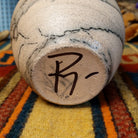 This distinctive Small Horsehair Pottery by Roger Calhoun features a tapered ceramic vessel with natural earth tones, black horsehair patterns, a decorative black-and-white crackled upper section, and a wide black rim; underside and artisan signature view.