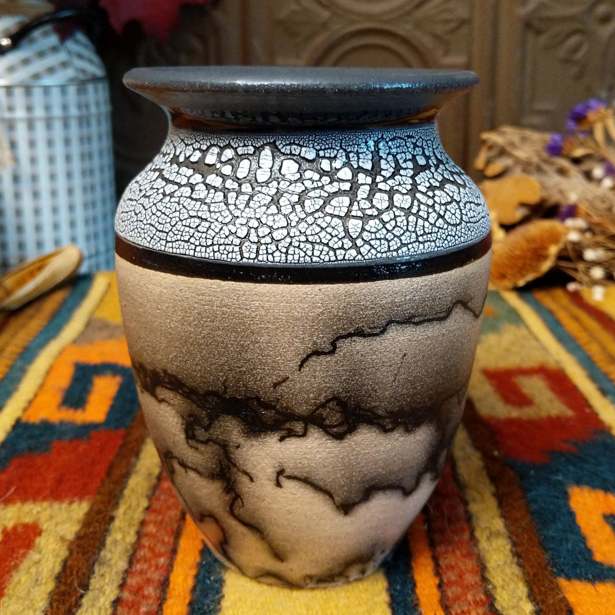 This distinctive Small Horsehair Pottery by Roger Calhoun features a tapered ceramic vessel with natural earth tones, black horsehair patterns, a decorative black-and-white crackled upper section, and a wide black rim.