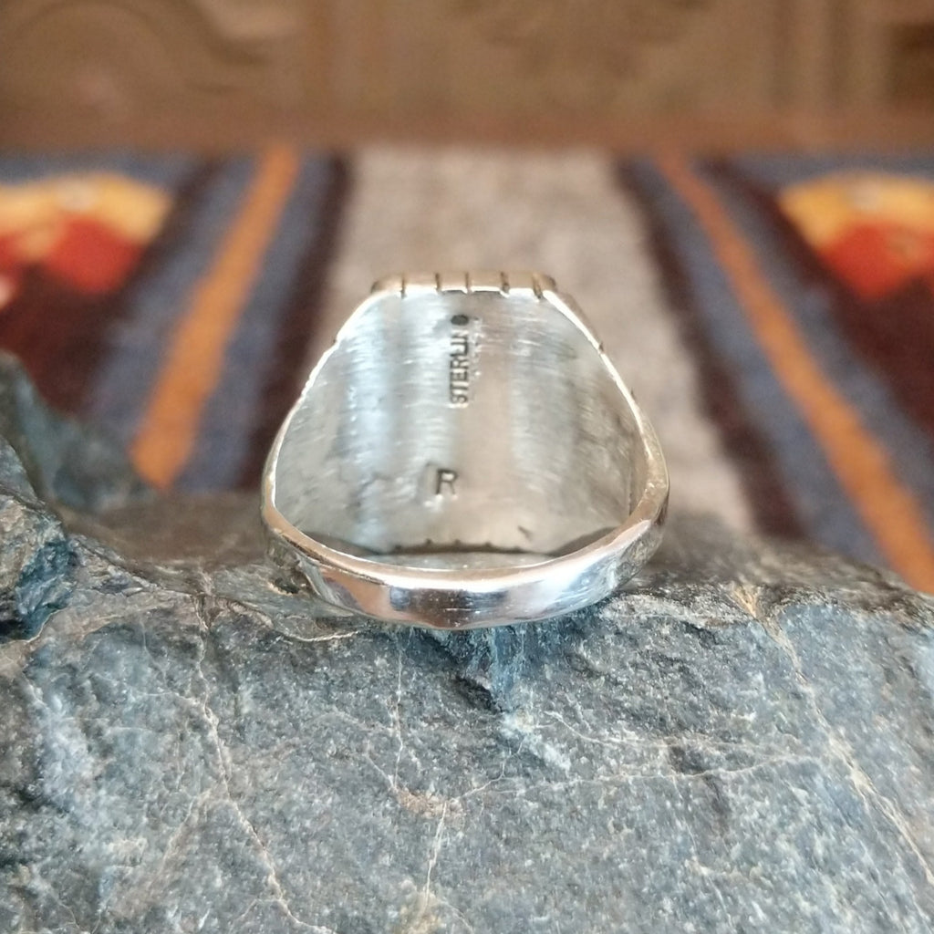The ring's polished sterling silver band tapers toward the center.