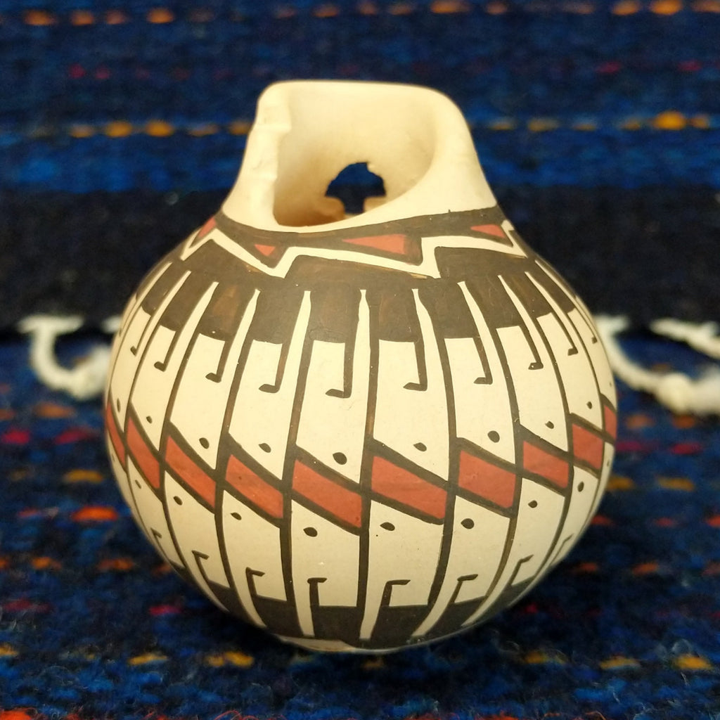 White clay body with black and red stepped patterns around the neck.