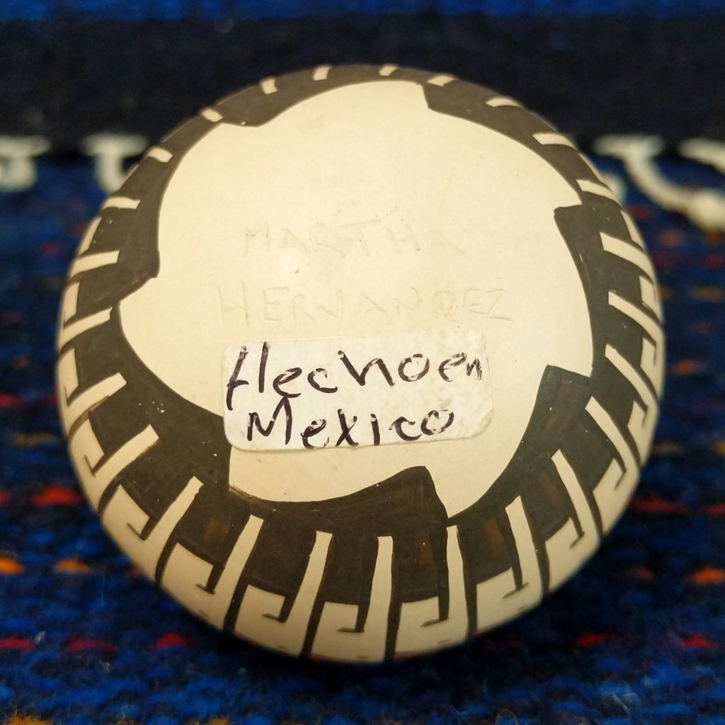 The artist's signature is etched onto the bottom of the pot.