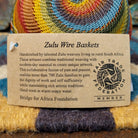 Handwoven small wire art bowl by Bridge for Africa featuring a spiral pattern in recycled wire with mustard yellow, olive green, dusty blue, rust, terracotta, brown, and charcoal tones, ideal for home décor or as a decorative catchall; artisan information.