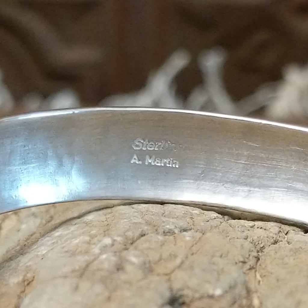 The artisan's signature is found on the interior of the cuff.