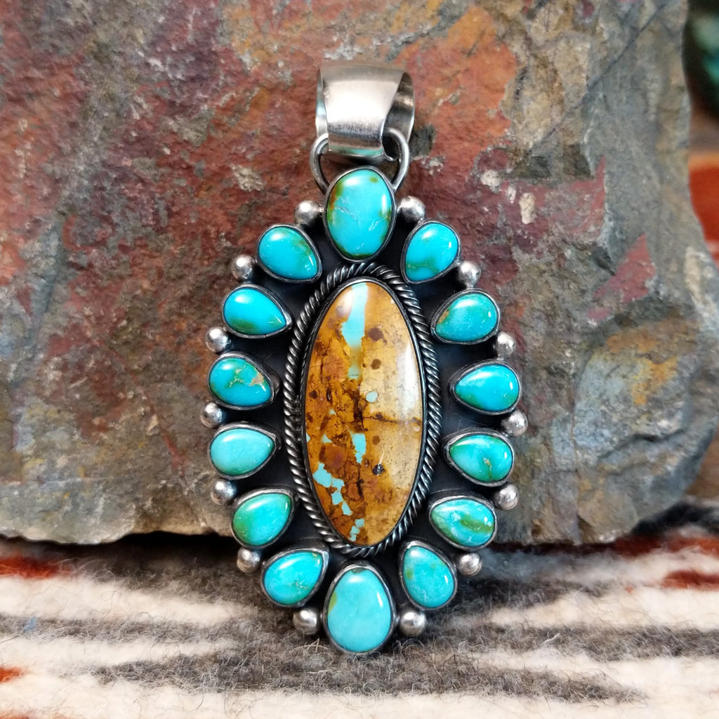 Sterling silver setting with cabochons of Sonoran Gold turquoise and Boulder turquoise, twisted rope accents, and dotted details.
