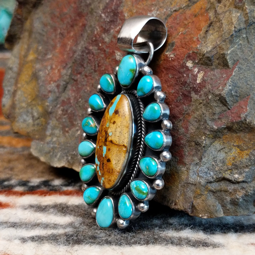 Sterling silver setting with cabochons of Sonoran Gold turquoise and Boulder turquoise, twisted rope accents, and dotted details.