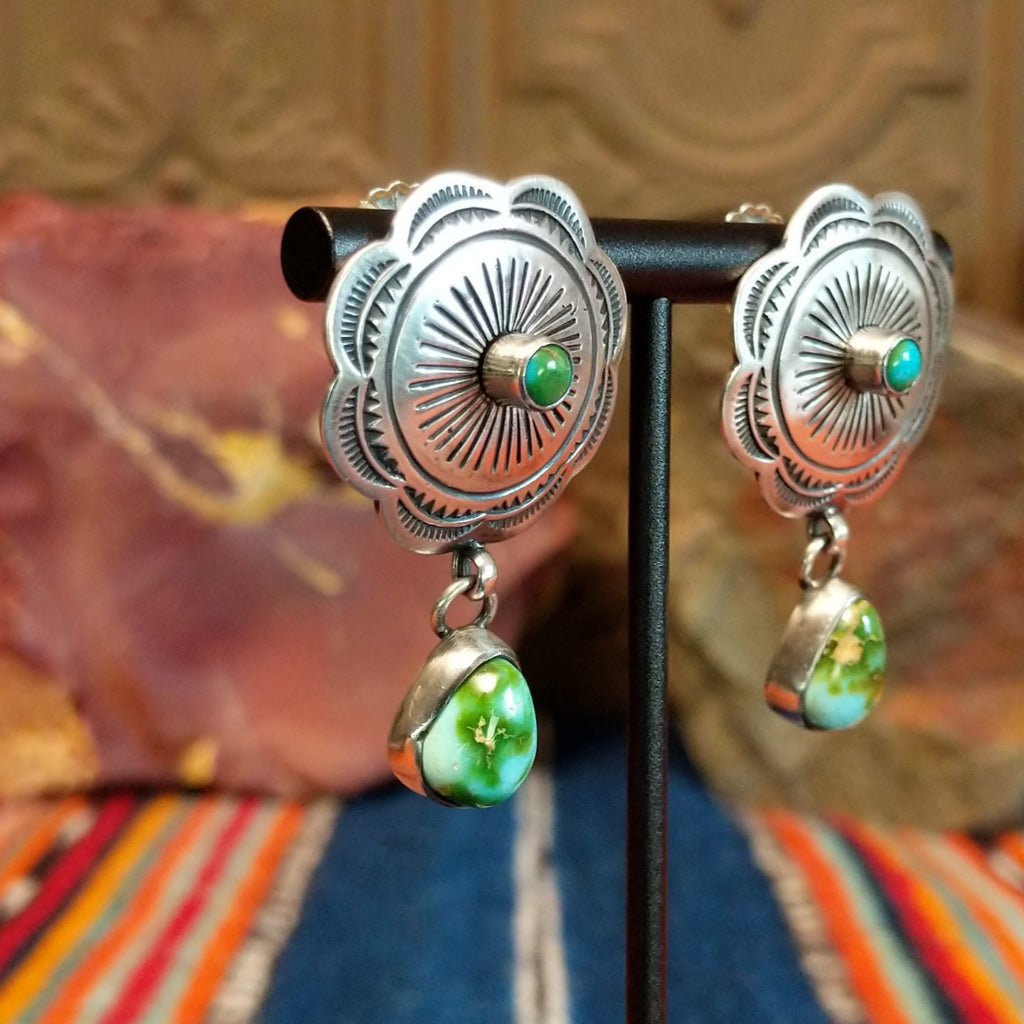 Concho earrings with intricate designs and singular teardrop shaped Sonoran Gold turquoise dangling from the bottom.