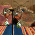 Concho earrings with intricate designs and singular teardrop shaped Sonoran Gold turquoise dangling from the bottom.