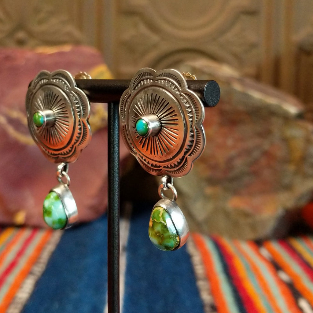 Concho earrings with intricate designs and singular teardrop shaped Sonoran Gold turquoise dangling from the bottom.