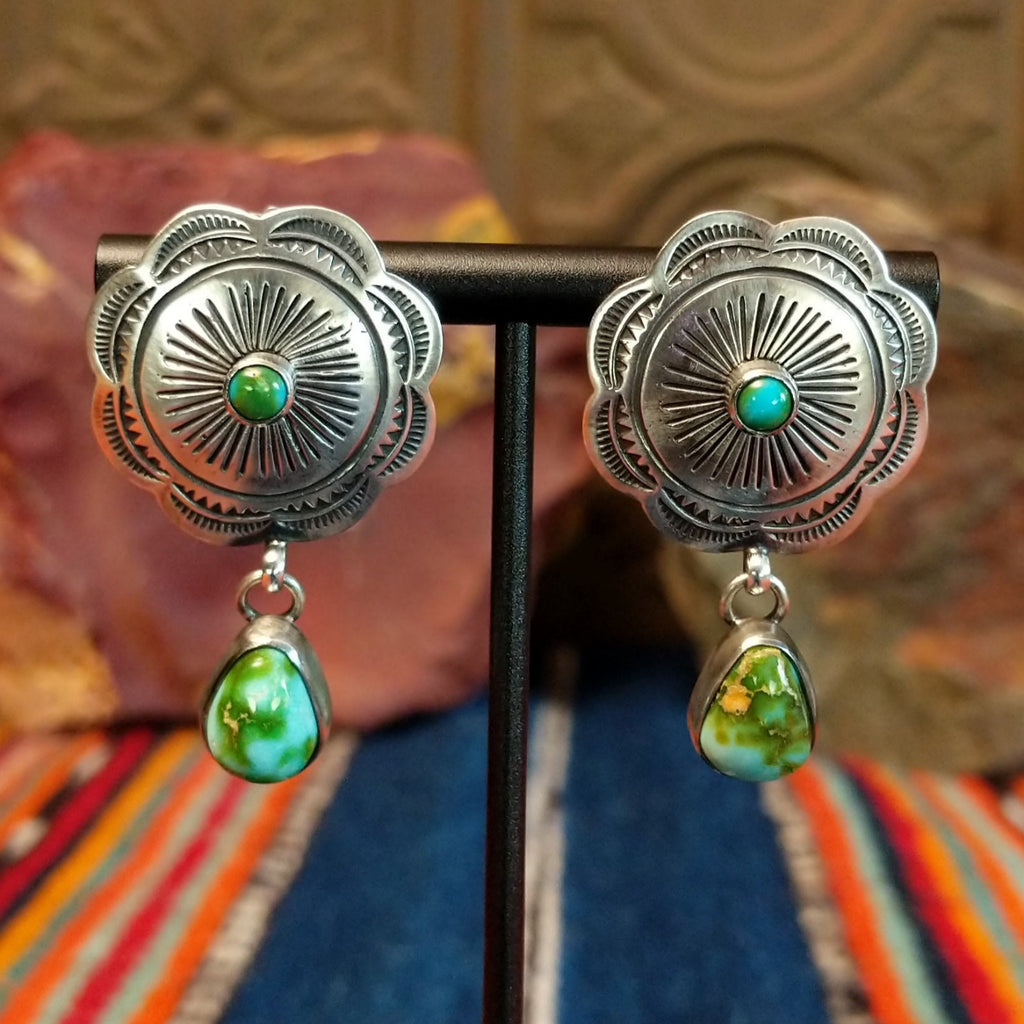 Concho earrings with intricate designs and singular teardrop shaped Sonoran Gold turquoise dangling from the bottom.