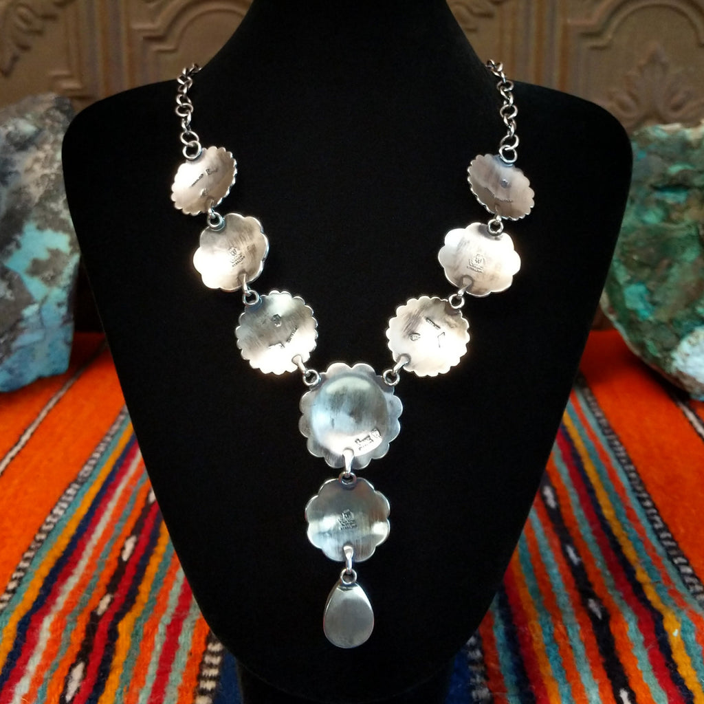 The smooth sterling silver of the conchos making up the necklace.