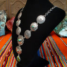 Small Sonoran Gold turquoise set in bezels that are atop the intricately decorated conchos with singural teardrop pendant.