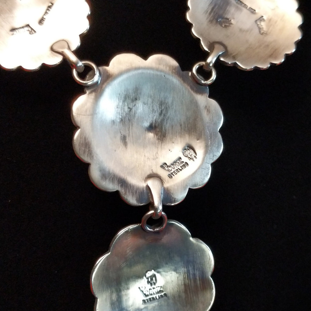 The artisan's signature is stamped onto the back of the conchos.