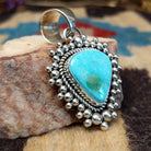Sterling silver pendant featuring Sonoran Gold turquoise with green-blue tones and natural matrix, accented by dotted silver beadwork and handcrafted by Navajo artist Artie Yellowhorse.  Side view.