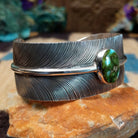 Sonoran Gold turquoise feather cuff by Angela Martin, featuring a vibrant turquoise stone, detailed feather design, and handcrafted Southwestern-inspired metalwork.  Side view.