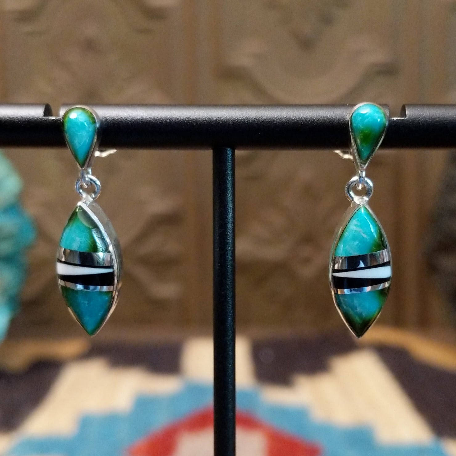 Sterling silver drop earrings with a multistone inlay. 