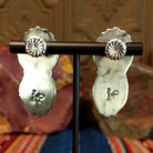 The sterling silver stud backings of the drop earrings and artisan's initials stamped.