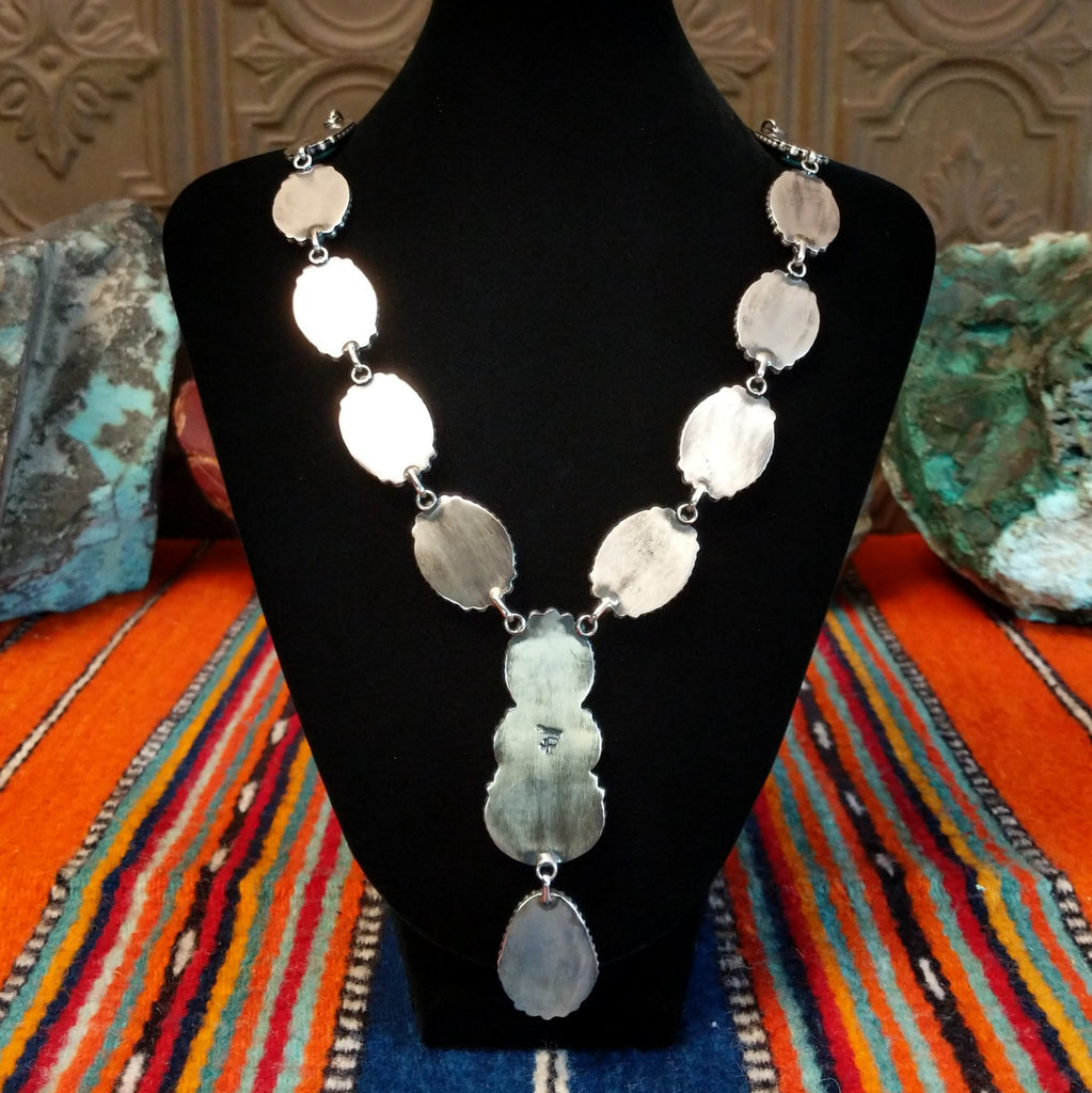 Smooth sterling silver bezel backings of the necklace.