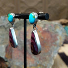 Handcrafted sterling silver Sonoran Gold turquoise and purple spiny oyster earrings by Lucy Jake, featuring a two-stone dangle design; side view.