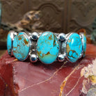 Sterling silver cuff bracelet with Sonoran gold turquoise set in notched, oval bezels. 
