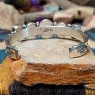 Handcrafted Navajo sterling silver cuff by Roie Jaque featuring five Sonoran Gold turquoise cabochons, including a rope-bordered center stone accented with polished silver bead details; underside view.