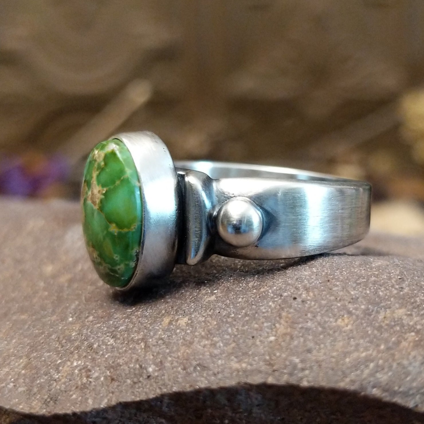 Sterling silver ring with Sonoran gold turquoise set in a raised, oval bezel and brushed finish.