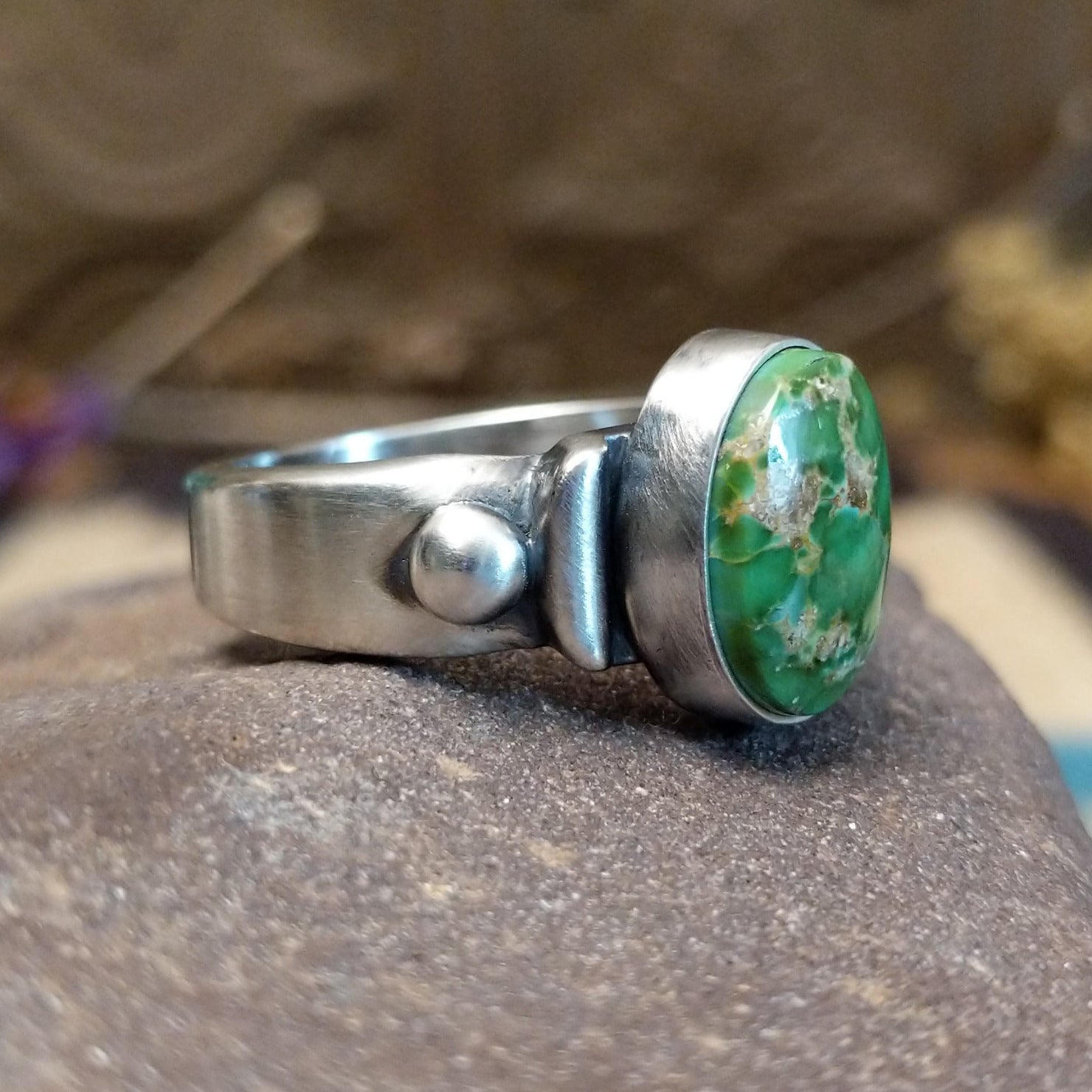 Sterling silver ring with Sonoran gold turquoise set in a raised, oval bezel and brushed finish.