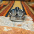 This captivating Sonoran Gold Turquoise Ring by Linda Marble features a large teardrop-shaped blue-green turquoise stone with golden-brown matrix, set in a silver bezel with a wide, intricately stamped silver band; underside view.