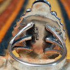 This distinctive Sonoran Gold Turquoise Ring by Roie Jaque features an oval blue-green turquoise stone with natural matrix, framed by silver rope detailing, polished silver beads, and a decorative silver accent at the top; artisan and Sterling Silver stamp.