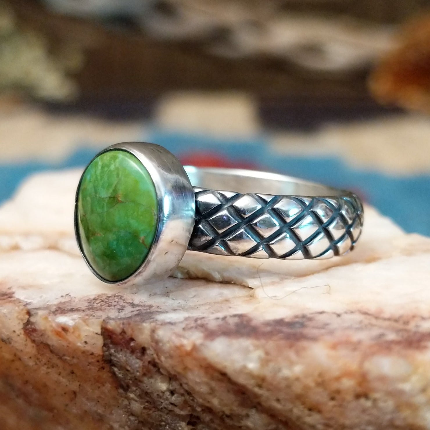Sterling silver ring with Sonoran gold turquoise set in a round bezel and basket stamps along the band.
