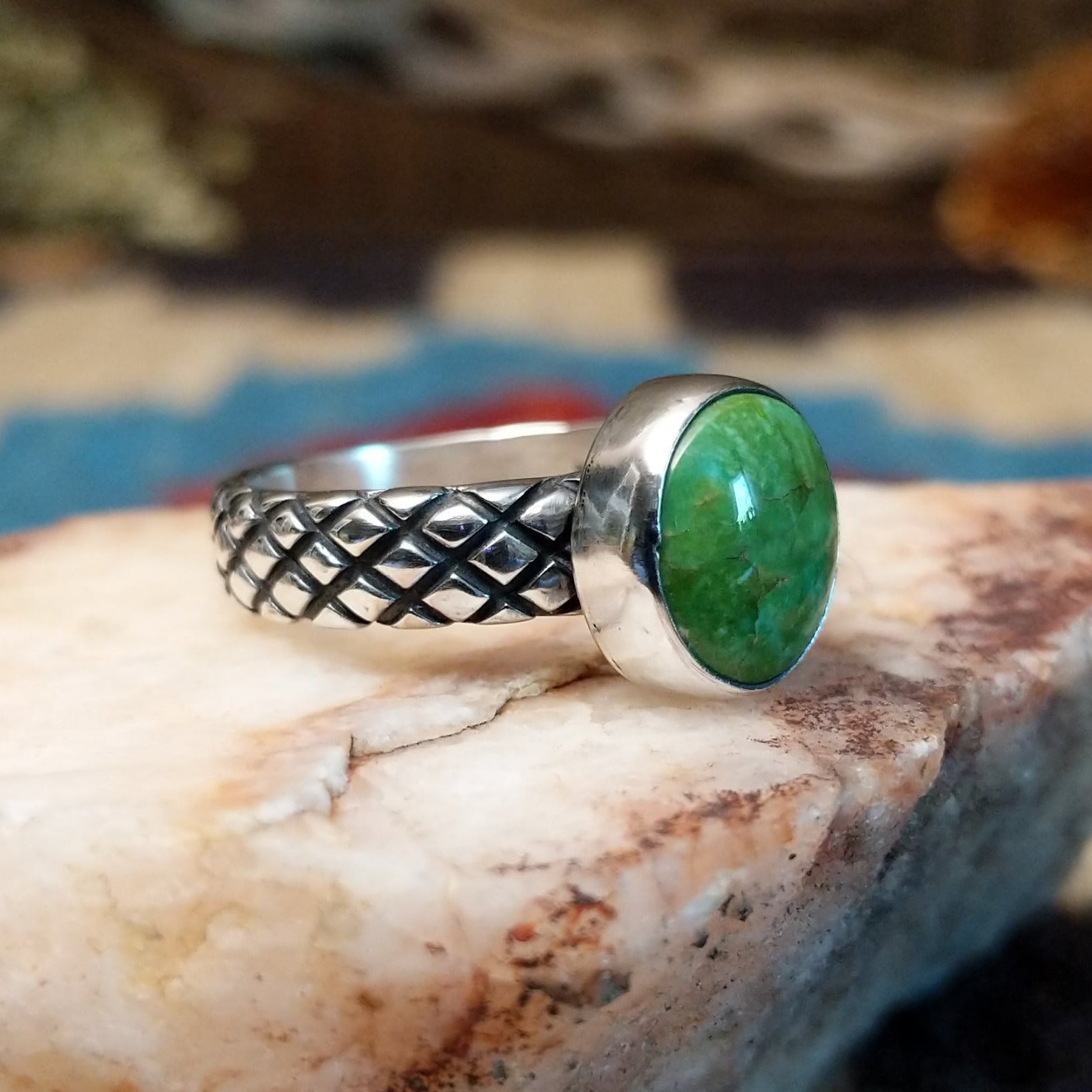 Sterling silver ring with Sonoran gold turquoise set in a round bezel and basket stamps along the band.