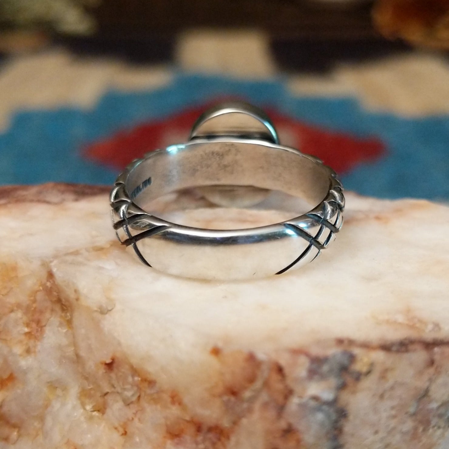 Sterling silver ring with Sonoran gold turquoise set in a round bezel and basket stamps along the band.