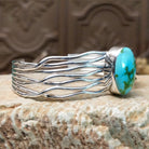 Sterling silver cuff bracelet with Sonoran gold turquoise set in the oval bezel and seven strands of silver making up the band.