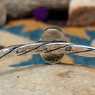 Handcrafted sterling silver twisted cuff by Raymond Coriz featuring an oval Sonoran Gold turquoise cabochon with vibrant blue, green, and natural golden matrix; artisan and Sterling Silver stamp.