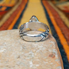 Sonoran Gold Turquoise Ring by Raymond Coriz featuring a pear-shaped green turquoise stone with natural matrix, set in sterling silver with a smooth bezel and decorative braided band; underside view.