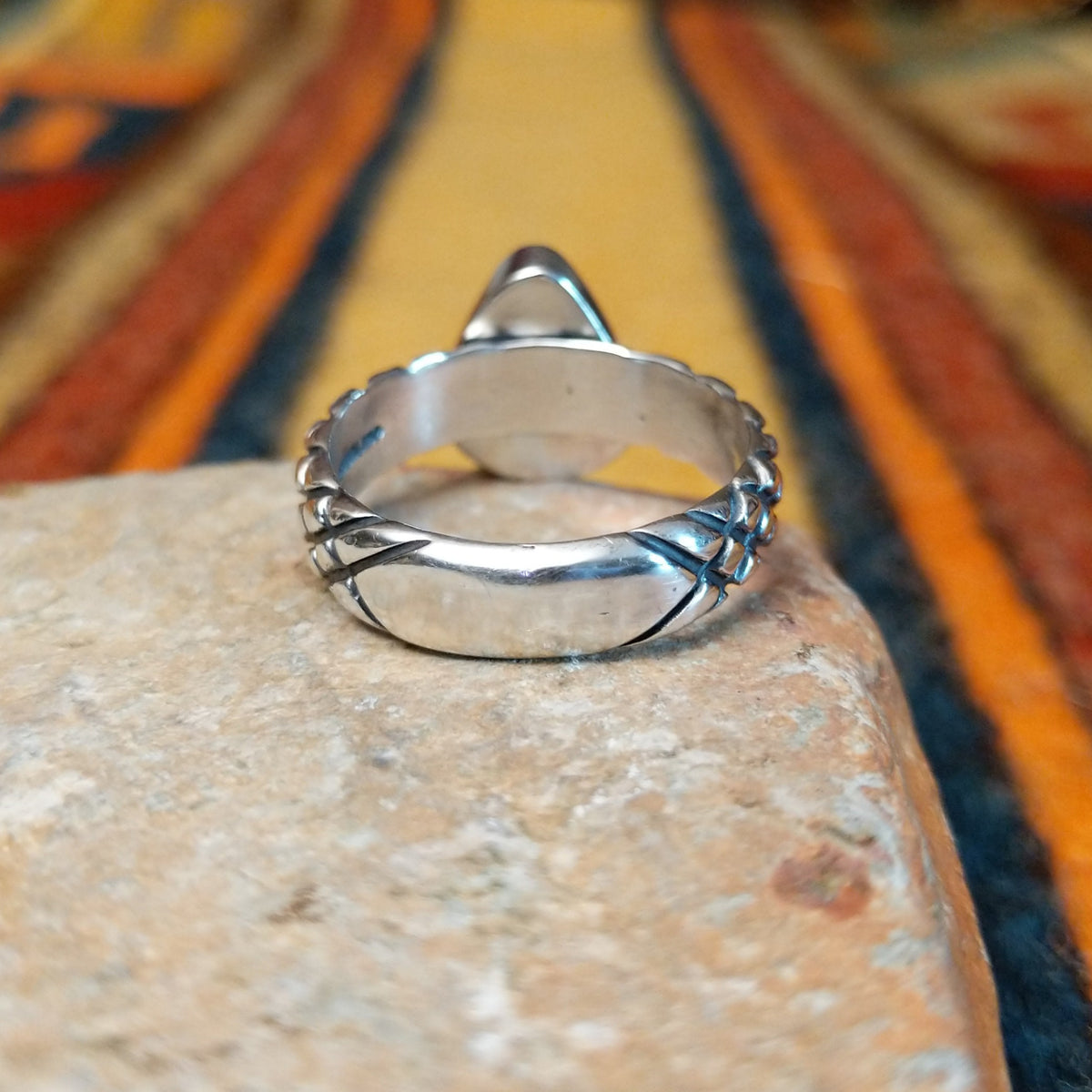 Sonoran Gold Turquoise Ring by Raymond Coriz featuring a pear-shaped green turquoise stone with natural matrix, set in sterling silver with a smooth bezel and decorative braided band; underside view.