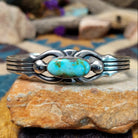Handcrafted Navajo sterling silver cuff by Raymond Coriz featuring an oval Sonoran Mountain turquoise cabochon with polished silver bead accents, openwork scroll detailing, and a triple-split cuff design.