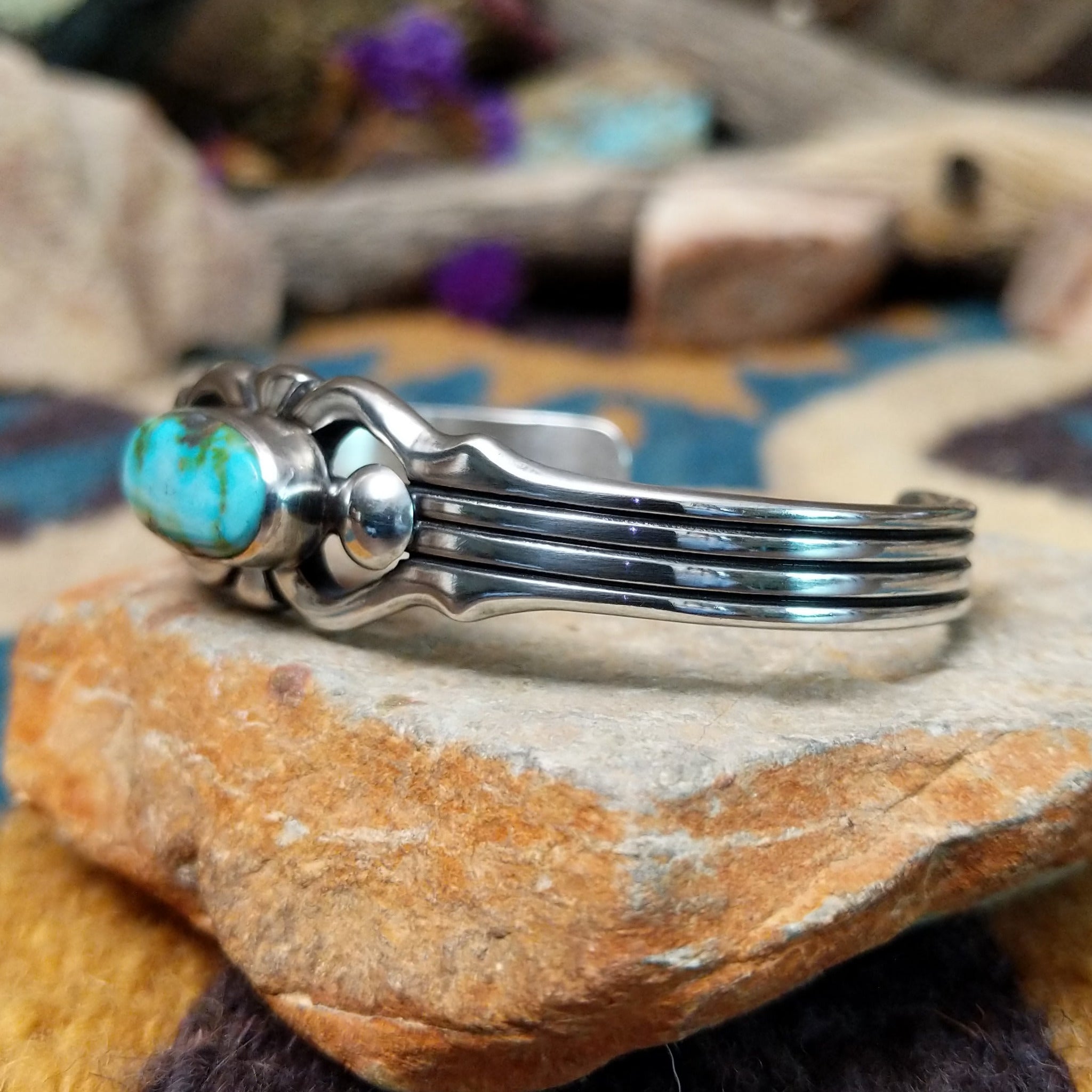 Handcrafted Navajo sterling silver cuff by Raymond Coriz featuring an oval Sonoran Mountain turquoise cabochon with polished silver bead accents, openwork scroll detailing, and a triple-split cuff design; side view.