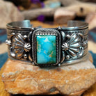 Handcrafted Navajo sterling silver cuff by Murphy Platero featuring a rectangular Sonoran Mountain turquoise cabochon with a twisted rope bezel, repoussé conchos, hand-stamped details, and polished silver accents.