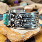 Handcrafted Navajo sterling silver cuff by Murphy Platero featuring a rectangular Sonoran Mountain turquoise cabochon with a twisted rope bezel, repoussé conchos, hand-stamped details, and polished silver accents; side view.