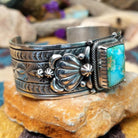 Handcrafted Navajo sterling silver cuff by Murphy Platero featuring a rectangular Sonoran Mountain turquoise cabochon with a twisted rope bezel, repoussé conchos, hand-stamped details, and polished silver accents; side view.
