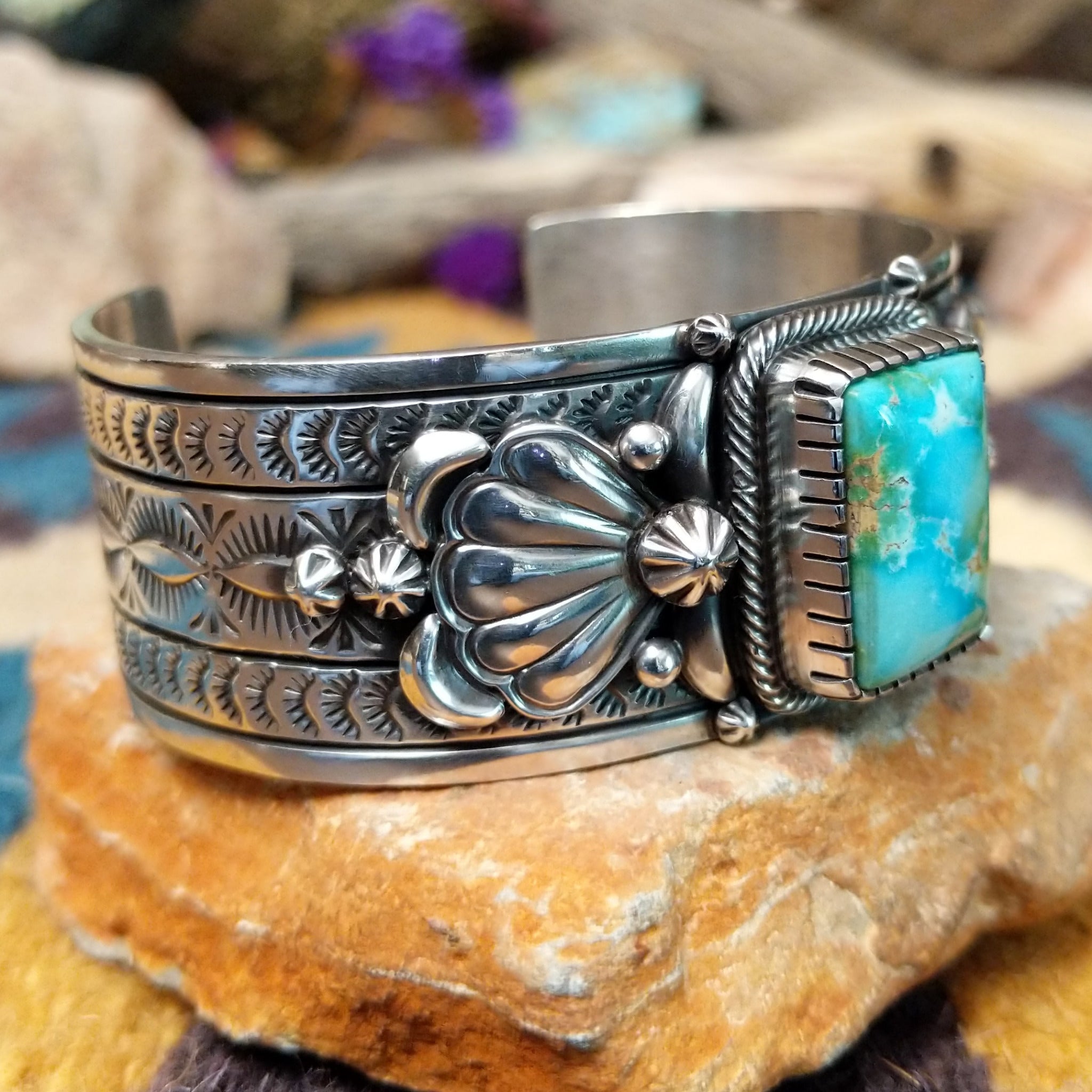 Handcrafted Navajo sterling silver cuff by Murphy Platero featuring a rectangular Sonoran Mountain turquoise cabochon with a twisted rope bezel, repoussé conchos, hand-stamped details, and polished silver accents; side view.