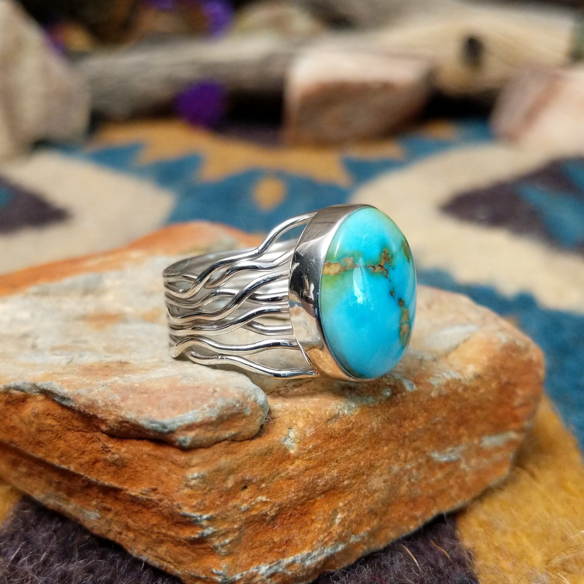 Sterling silver Sonoran Mountain Turquoise ring by Angela Martin with an oval sky-blue gemstone and natural golden matrix; side view.