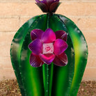 Close-up reveals the purple flowers and intricate detailing along the cactus edges.